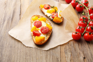 Tasty bruschetta with tomatoes, on old wooden table