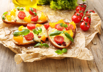 Tasty bruschetta with tomatoes, on old wooden table