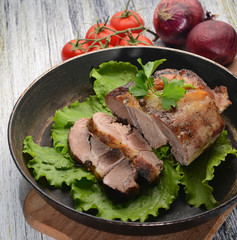 pork slices on lettuce with tomatoes and onions