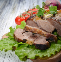 pork slices on lettuce with tomatoes and onions