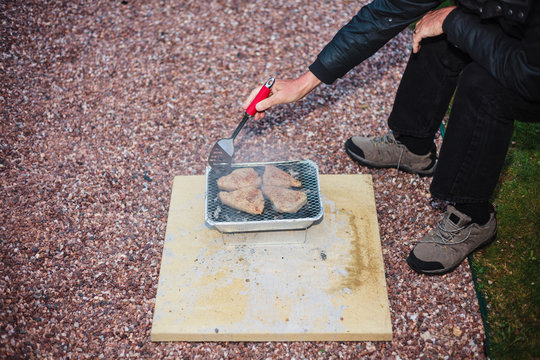 Senior Man Grilling Fish Outside