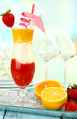 Delicious fruit smoothie on wooden table on light background