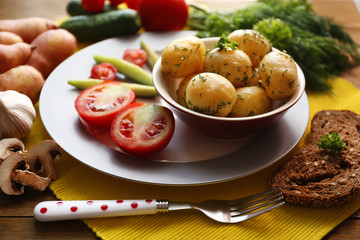 Young boiled potatoes in pan on wooden table