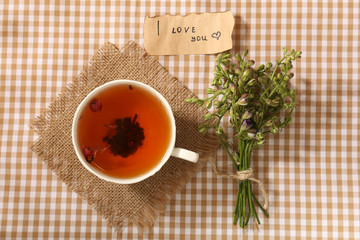 Cup of fresh herbal tea on table