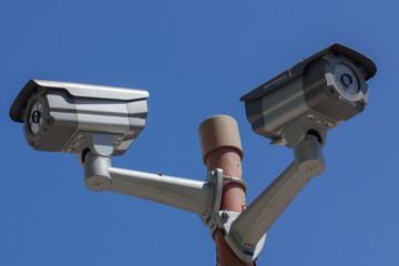 two security cameras on blue sky background