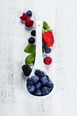 Berries with spoon  on Wooden Background.