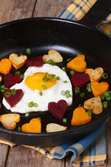 Egg in the form of heart in a pan with vegetables. Vertical