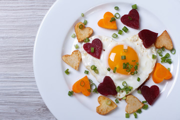 Romantic breakfast of fried hearts of vegetables and eggs