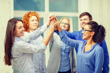 creative team doing high five gesture in office