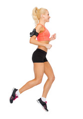 Fototapeta na wymiar sporty woman running with smartphone and earphones
