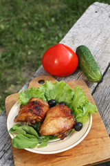 chicken grilled on a plate with salad, olives and arugula
