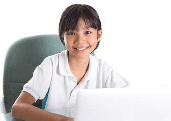 Young Asian Malay girl sitting at her desk with a laptop