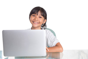 Young Asian Malay girl sitting at her desk with a laptop