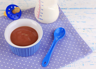 Baby food and milk on wooden table
