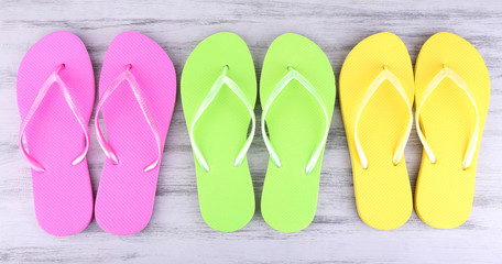 Bright flip-flops on color wooden background