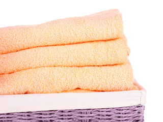 Color towels in wicket basket, isolated on white