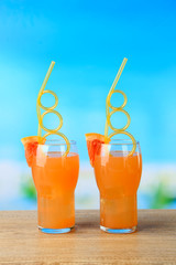 Grapefruit cocktail with cocktail straw on bright background