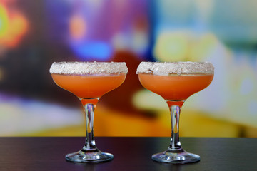 Grapefruit cocktail in glasses on bright background