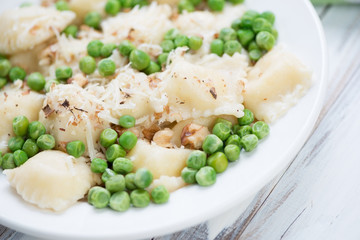 Square italian ravioli with green peas, walnuts and cheese