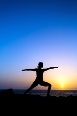 Fototapeta premium Woman doing yoga sunset silhouette