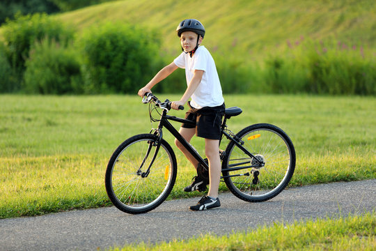 Teenage boy on bike in city park
