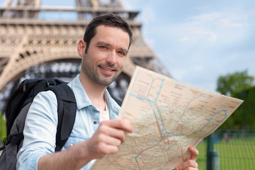 Young attractive tourist reading map in Paris
