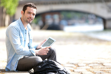 Young attractive tourist using tablet in Paris