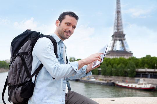 Young attractive tourist using tablet in Paris