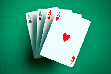 four aces on green casino table