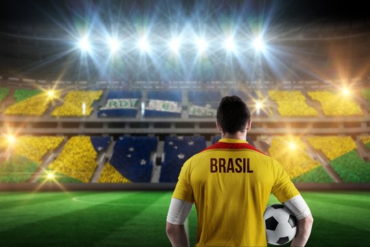 Composite image of brasil football player holding ball - Powered by Adobe