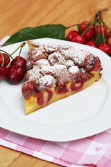 fetta di clafoutis con ciliegie su tavolo_ dolce