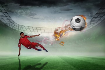 Composite image of football player in red kicking
