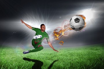 Obraz na płótnie Canvas Composite image of football player in green kicking
