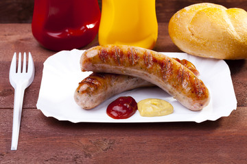 Roasted sausage with bread served on a paper tray