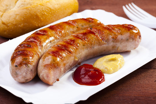 Roasted sausage with bread served on a paper tray