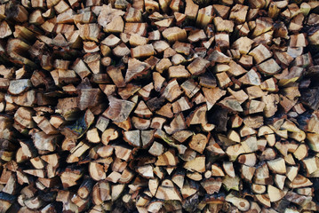Background of dry chopped firewood logs in a pile