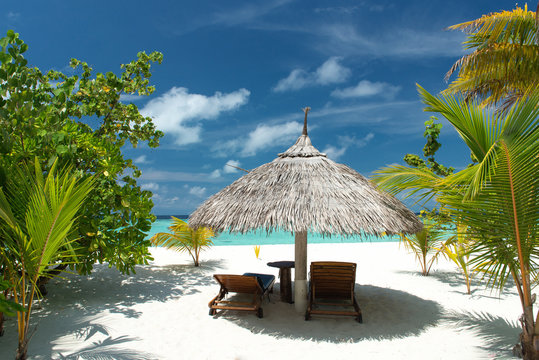 Liegestuhl mit Sonnenschirm am Strand