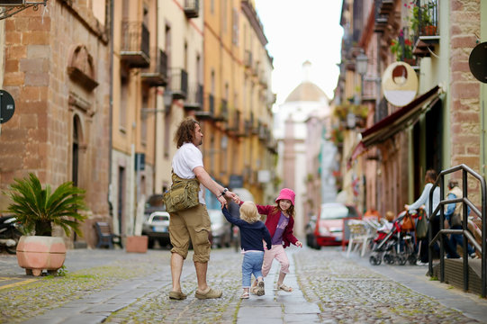 Two little sisters and their dad in italian town