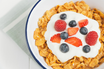 Healthy breakfast with cereals and berries in an enamel bowl