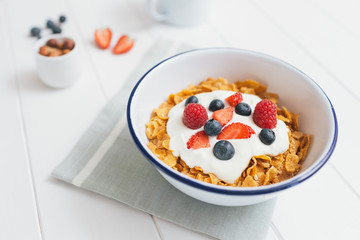 Healthy breakfast with cereals and berries in an enamel bowl