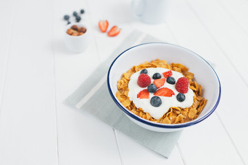 Healthy breakfast with cereals and berries in an enamel bowl