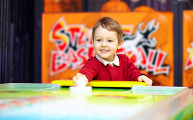 happy child playing table air hockey