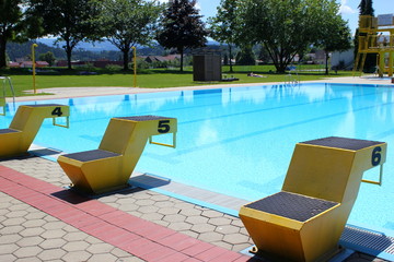 Schwimmbad: Startblöcke am Rand eines Beckens im Freibad