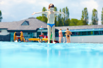 happy kid boy ready to jump in pool