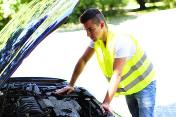 junger Mann &uuml;berpr&uuml;ft den Motor