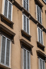sunlit old building with closed wooden shutters