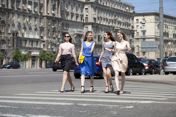 Obraz premium Four beautiful fashion girls walking on the street