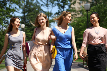 Four beautiful fashion girls walking on the street