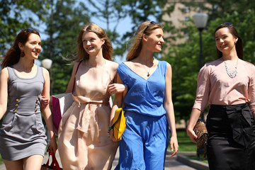 Four beautiful fashion girls walking on the street