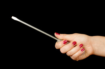 Female hand holding long flat screwdriver isolated on the black